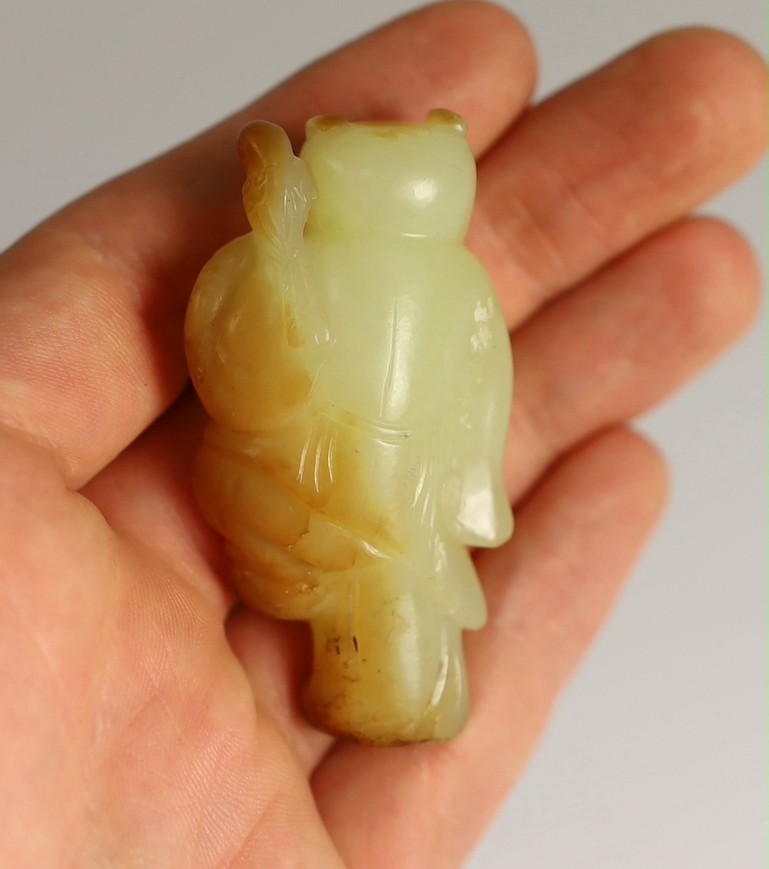 A rare Chinese yellow and russet jade figure of a boy holding a parrot, 18th/19th century, 5.6cm high, wood stand